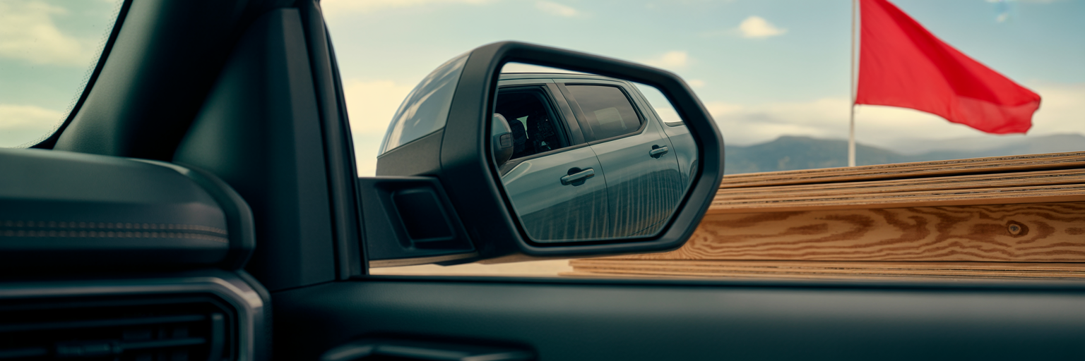 View of extended plywood load in truck mirror.